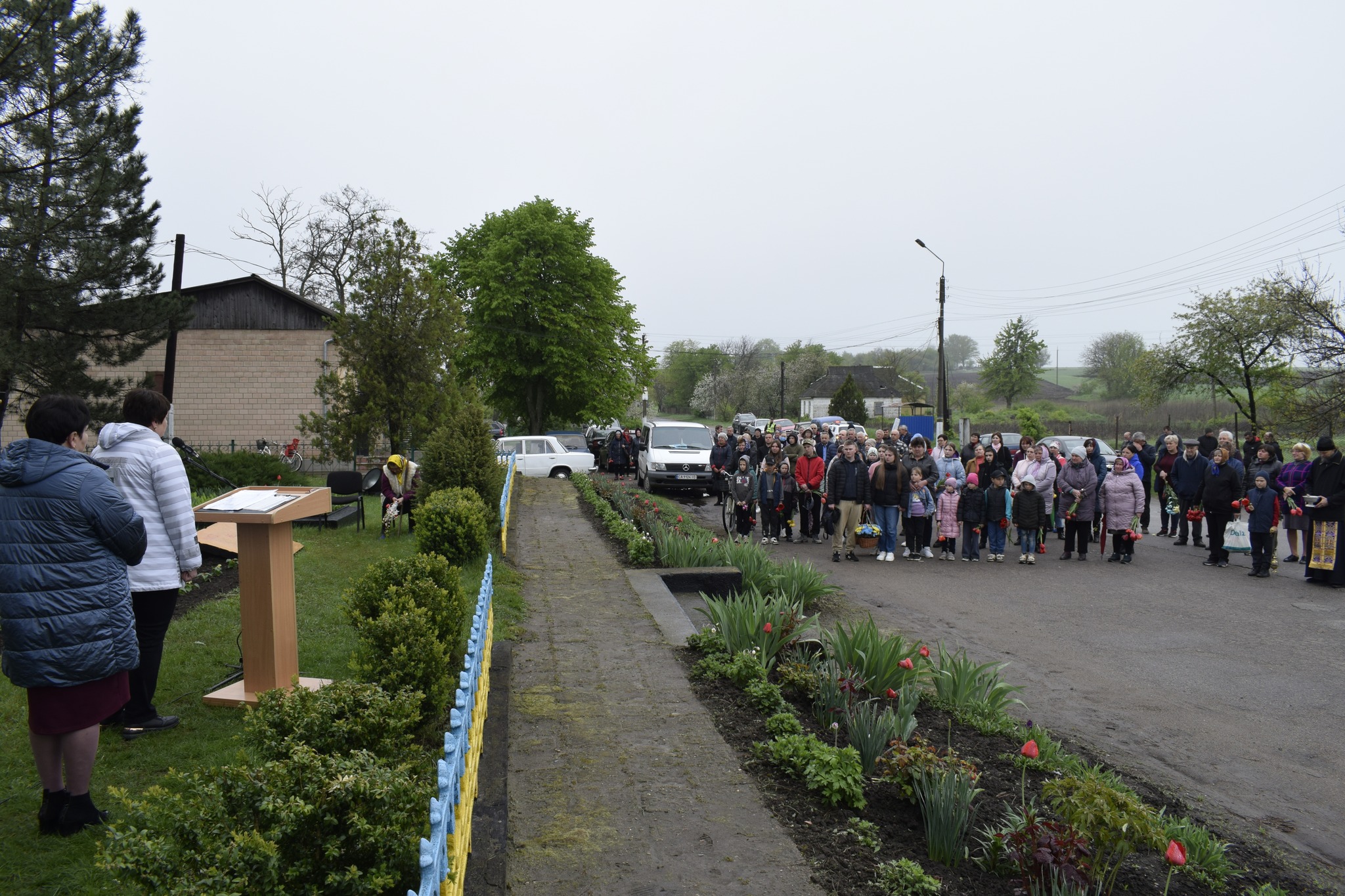 люди стоять на відкритті меморіального стенду