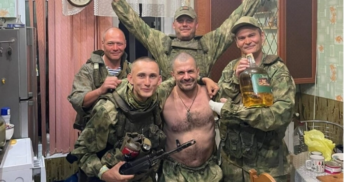 Станіслав Асонов (з автоматом) та інші військові РФ у пограбованому ними приватному будинку в Білозерці/ ЦЖР, фото з соцмереж