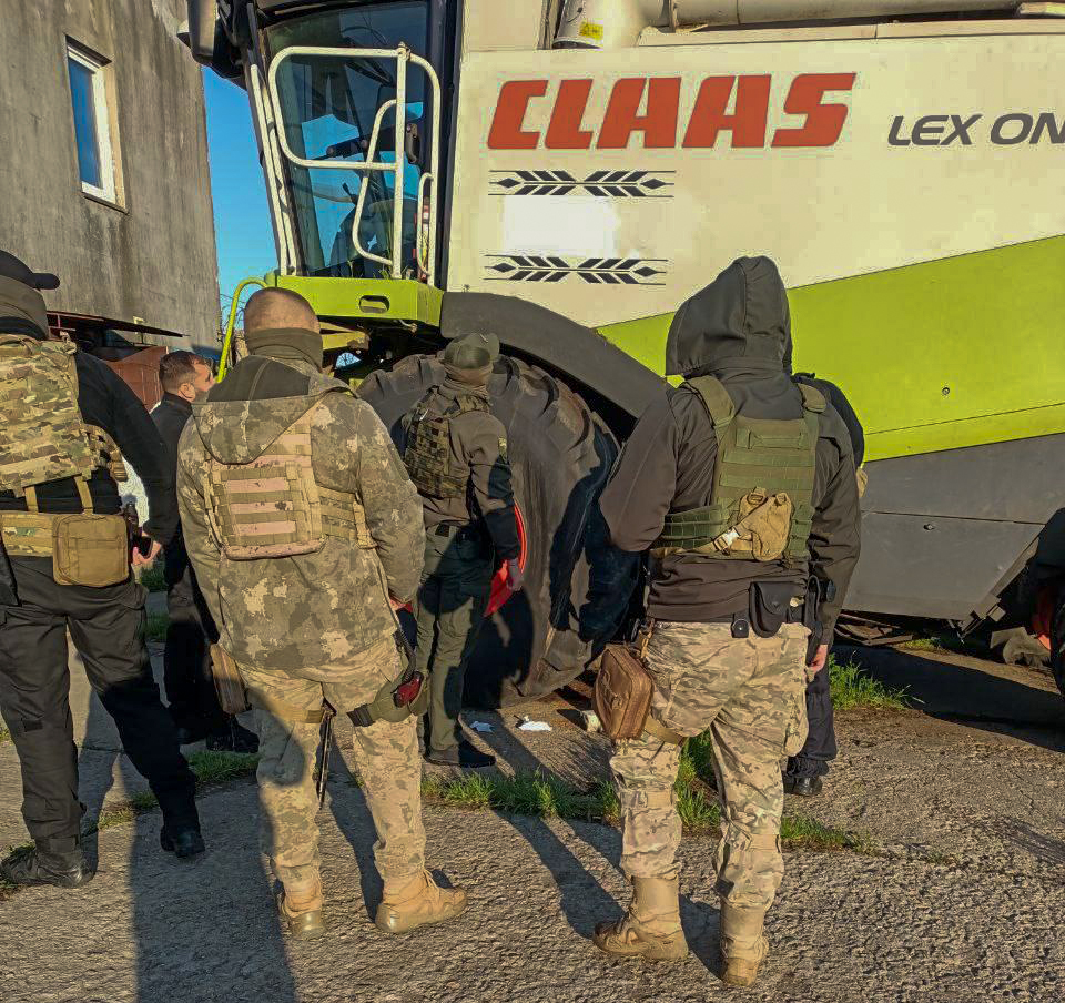 Люди у військовій формі біля комбайну CLAAS