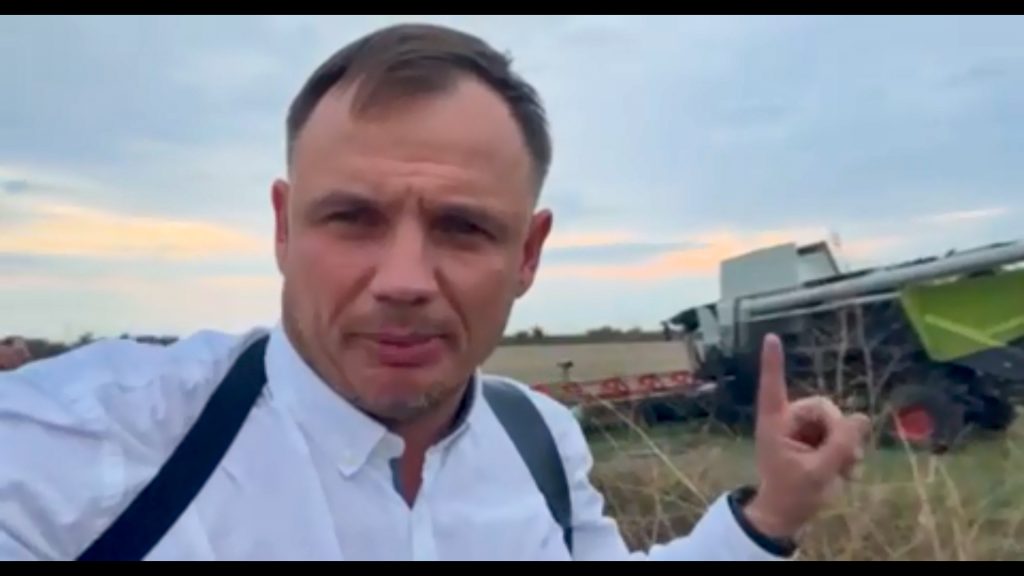 Кирило Стремоусов на фоні комбайну