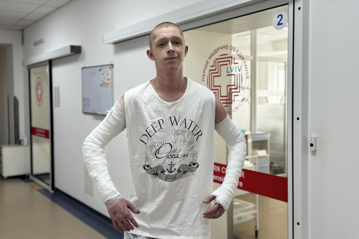 Пацієнт – Богдан Гапій стоїть у холі лікарні святого Луки, він одягнений у футболку білого кольору, обидві обпечені руки – перев’язані спеціальним медичним бинтом