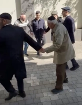 Євген Бондер під час відвідин синагоги (в плащі) / Головний рабин України