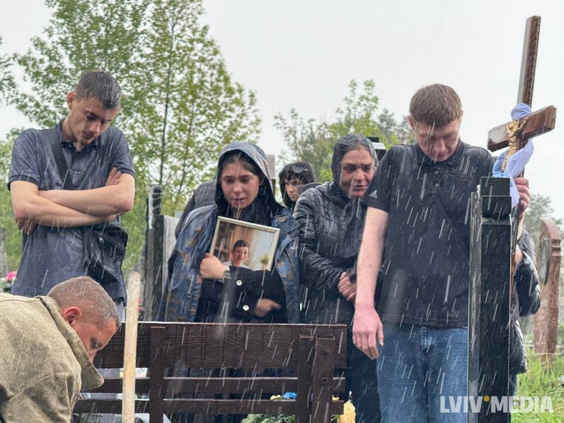 Шваґер Андрій тримає хрест на цвинтарі на могилі Владислава